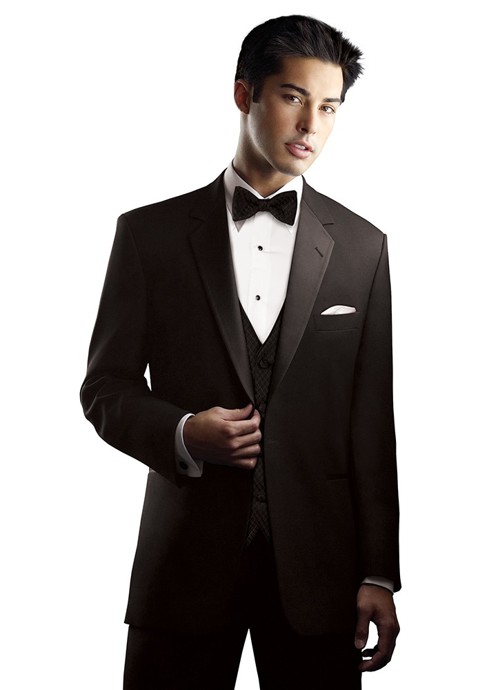 A man in a black tuxedo holds the edge of his notch lapel.
