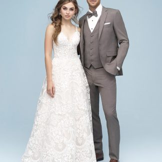 A handsome man in the Sandstone Beige Brunswick Suit by Allure Men stands next to his bride in a white wedding dress.