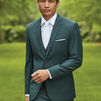 A man in a green suit stands in front of a very green courtyard.