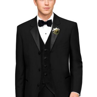 A Man in a black Tuxedo stands with his arms at his side